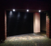 Black garage door lit up by spotlights In Comber, Belfast & North Down